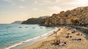 Spiaggia libera sabbiosa a Celle Ligure al tramonto con borgo marinaro